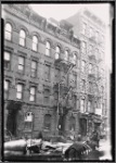 Tenements and storefront; horse and wagon: Manhattan