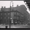 Vacant wood frame tenement with storefronts; Bishop's crook lamp: 9th Ave. - W. 17th St., Manhattan
