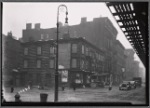 Vacant wood frame tenement with storefronts; Bishop's crook lamp: 9th Ave. - W. 17th St., Manhattan