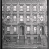 Brownstone row; woman reading newspaper outside