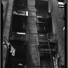 Tenement rear with fire escapes used for storage; hanging laundry