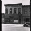 Wooden row house with vacant storefront