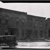 Vacant wooden houses; dirt sidewalk: Brooklyn?