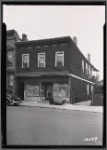 Two story frame building with vacant storefront: Queens