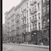 Street view of tenements, residents and apartment to let signs