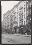 Street view of tenements, residents and apartment to let signs