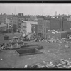 View of low rise neighborhood from demolition debris strewn roof;