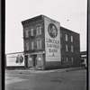 Vacant tenement with Lincoln Savings Bank billboard; 1937 Chevrolet ad