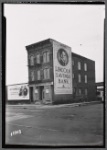 Vacant tenement with Lincoln Savings Bank billboard; 1937 Chevrolet ad