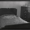 Middle class apartment bedroom with bed and bureau