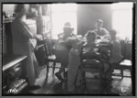 Well appointed kitchen with mother watching six children at table
