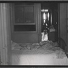 Railroad apartment interior with unmade bed