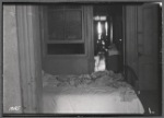 Railroad apartment interior with unmade bed