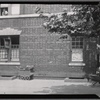 Apartment house with beauty salon on first floor; woman with baby carriage