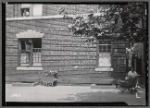 Apartment house with beauty salon on first floor; woman with baby carriage