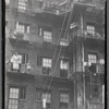 Chelsea (?) tenement rear with tenants and plants on fire escapes: W 17th Street?, Manhattan