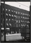 Tenement row with storefronts; Cider Cabin; National Biscuit Co. truck