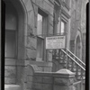 Furnished Rooms sign with rates in front of Brownell Apartments entrance