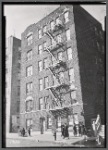Apartment house; residents outside with children: Bronx
