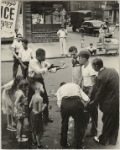 Eastside - Group of men and youths gathered around an accident victim; one young man appears to be arguing with the others, East Harlem, New York City