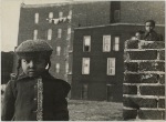 Young girl, with other children in background, in a vacant lot behind some tenement housing, East Harlem, New York City