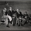 Zero Mostel [seated in center foreground], Sam Levene [seated at right foreground], Bill Becker [seated in background] and unidentified others in rehearsal for the stage production of The Good Soup