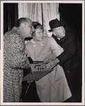 Elaine Stritch, Noël Coward, and restaurant owner Vincent Sardi in a promotional photograph in which they are pictured lighting the new electronic billboard for the original Broadway production of "Sail Away"