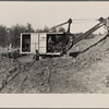Mechanical digger working on cellar foundation at one of the housing units at the Berwyn project, [Greenbelt,] Maryland.