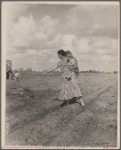 Mrs. Howard shows the beginning of a garden to a neighbor