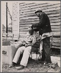 Negro getting a haircut in front of church which houses flood refugees. Sikeston, Missouri