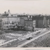 View of West 130th Street looking east towards Eighth Avenue, showing residential structures surrounded by vacant lots, Harlem, New York City, ca. 1940s