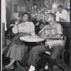 Claudia McNeil [sitting at left of table], John Bouie [sitting at right of table] and unidentified others in the stage production Simply Heavenly