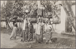 Young women on the way to temple bearing sacrificial offerings on their heads, Bali.