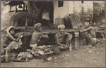 People squatting near dwelling, Bali.