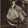 Oiran parade participant in geta sandals accompanied by servant bearing parasol.