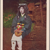 Oharame seated on bundle of firewood.