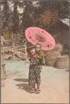 Girl with parasol carrying infant on back.