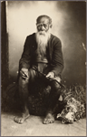 Studio portrait of seated man with long beard.