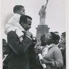 Harry Belafonte holds his son David on his shoulders while talking to visitors on Liberty Island, New York