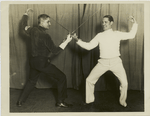 Spain's champion duellist arrives for an American invasion, New York City : Señor Juan Romero, Spain's youthful champion swordsman, who is here to test the metal of America's best, keeps in condition by fencing with Prof. Tonis Senac (left) with whom he is shown duelling.