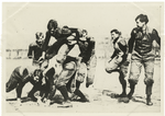 Eckersall of Chicago, teaching his backs to practice hurdling, when hurdling was allowable. Eckersall is the figure second from the right, with his leg drawn up, coaching.