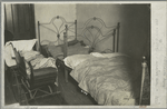 Dark bedroom showing 3 beds and baby carriage