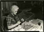Woman tieing string to glass bottles