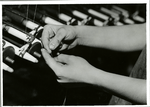Textile workers tying broken threads by hand