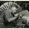 Skilled mechanic using micrometer to measure (to 1/1000 of one inch) the drive shaft he is fashioning