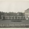View of Ellis Island buildings, with garden and trellises in foreground.