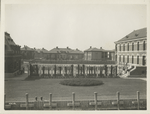 View of Ellis Island buildings, with garden and trellises in foreground.