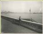 A derby-topped gentleman observing the harbor form the observation roof on one wing of the Immigration Station. The gentleman is possibly William Williams, Commissioner of Immigration at Ellis Island form 1902-5 and 1909-13, from whose estate these photographs came. The New York skyline, showing the nearly-completed Woolworth Building tower, is at the left.