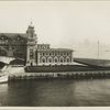 View of part of the front facade of the Immigration Station; the New York skyline is barely discernable through the haze in the background.