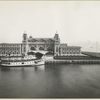 An excellent view of the front facade of the Immigration Station; a boat is docked in front.